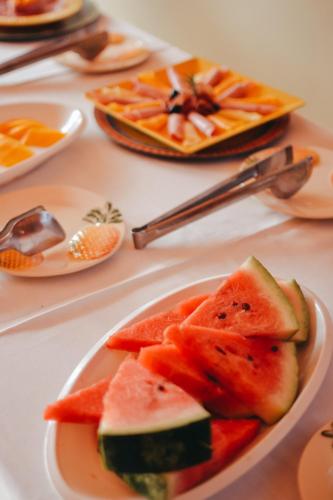 a white plate of fruit on a table at Ajubá Pousada in Morro de São Paulo