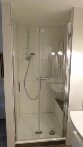 a shower with a glass door in a bathroom at Wohnung nahe Heidepark & Serengetipark in Bergen