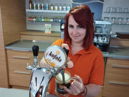 a woman is holding up a coffee machine at GAS Truck centrum in Holíč
