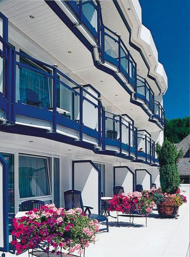 a building with blue balconies and flowers on a patio at Rüters Parkhotel in Willingen