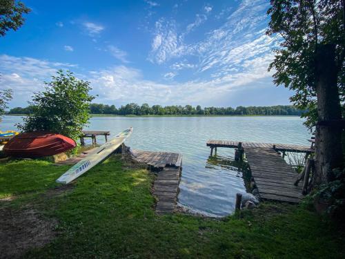 a boat is docked next to a dock on a lake at Haus Seeblick in Stary Gieląd