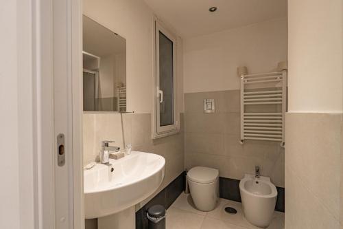 ein weißes Bad mit einem Waschbecken und einem WC in der Unterkunft Aureliana Apartments in Rom