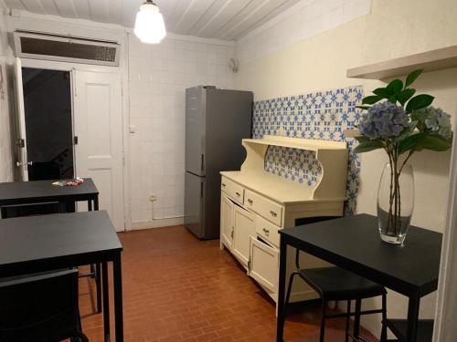 a kitchen with a refrigerator and a table and chairs at Alojamento VINTAGE BAIXA - TOMAR in Tomar