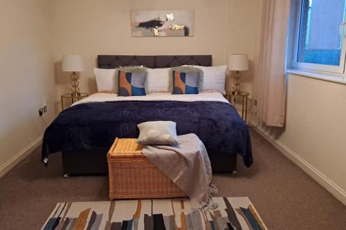 um quarto com uma cama grande e um edredão azul em Spacious 2 Bed Perfect for City Centre & Bay, Pool, Gym em Cardiff