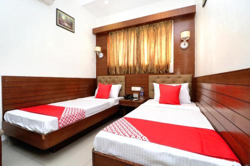 two beds in a hotel room with red and white sheets at OYO Heritage Corner in Patiāla