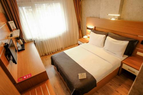 a hotel room with a bed and a window at Rhisos Otel in Rize