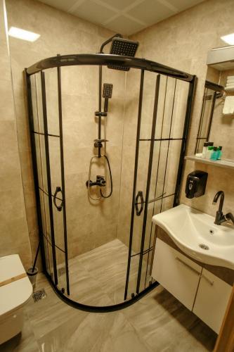 a bathroom with a shower and a sink at Rhisos Otel in Rize