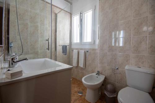 bagno bianco con servizi igienici e lavandino di T2 Apartamento do Tenis ad Albufeira