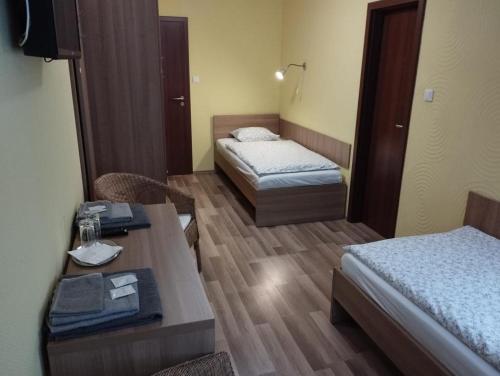 Cette chambre d'hôtel comprend deux lits, une table et des chaises. dans l'établissement GAS Truck centrum, à Holíč