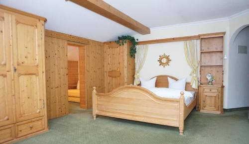 1 dormitorio con cama de madera y armarios de madera en Landhaus Achental en Pertisau