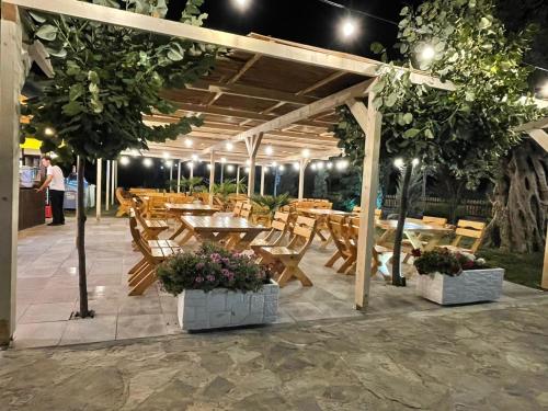 a wooden pergola with tables and chairs on a patio at Hotel Guri Shengjin in Lezhë