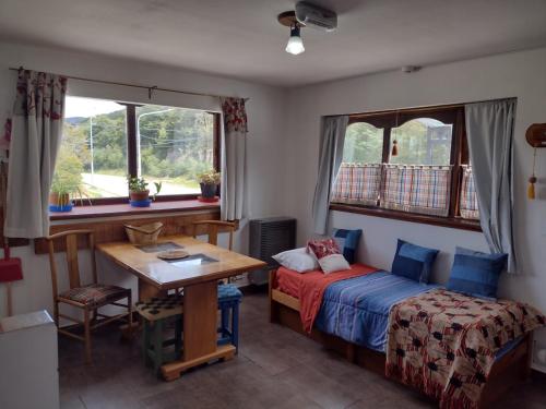 1 dormitorio con cama, mesa y ventana en El Rincón del Andino Planta Alta en Ushuaia