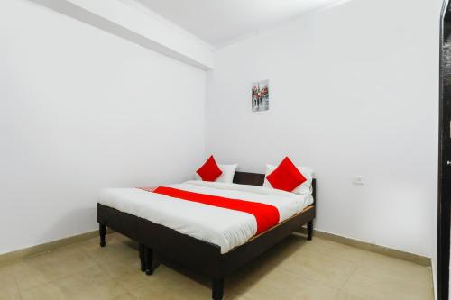 a bedroom with a bed with red pillows at OYO Hindon Residency in Ghaziabad