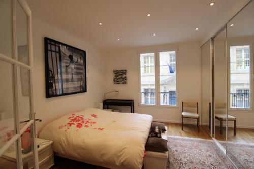 1 dormitorio con 1 cama y 2 ventanas en Paris - Trocadéro, en París