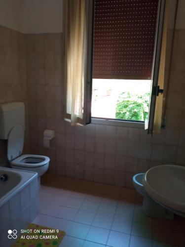 La salle de bains est pourvue de toilettes, d'un lavabo et d'une fenêtre. dans l'établissement Fiera Otto, à Bologne