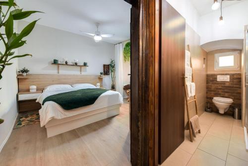 1 dormitorio con 1 cama y baño con aseo en City Center Studio Apartment for Humans & Pets - One, en Rijeka
