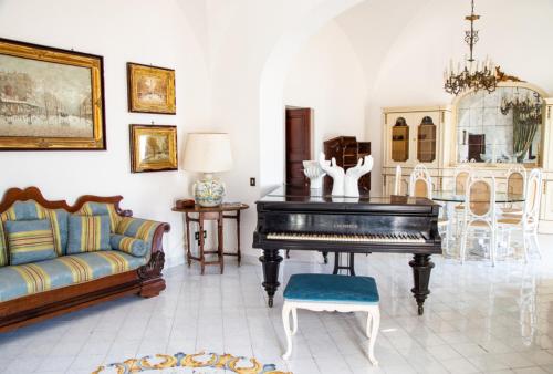 a living room with a piano and a couch at Villa 4 Colonne, Capri in Capri
