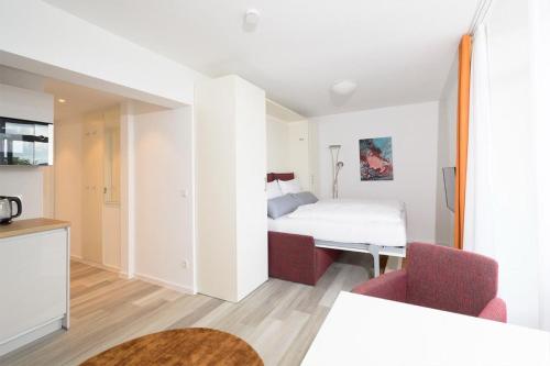 ein Hotelzimmer mit einem Bett und zwei Stühlen in der Unterkunft Huber Living Single 301 in Germering