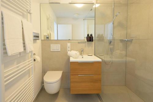 ein Bad mit einem WC, einem Waschbecken und einer Dusche in der Unterkunft Huber Living Single 301 in Germering