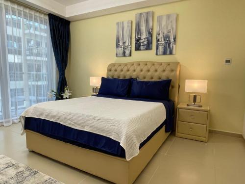 a bedroom with a bed and two pictures on the wall at Infinity Blue - Studio on Al Marjan Island with a private beach in Ras al Khaimah