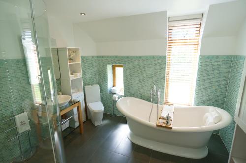 ein Badezimmer mit einer Badewanne, einem WC und einem Waschbecken in der Unterkunft East Lodge in Bolney