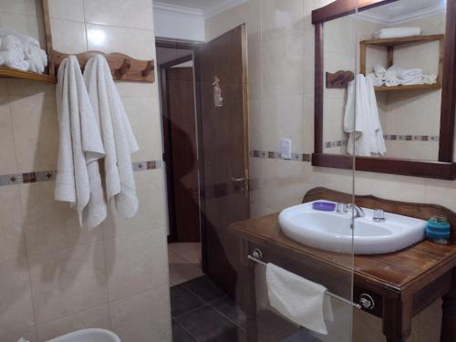 a bathroom with a white sink and a shower at El Rincón del Andino - Planta Baja in Ushuaia