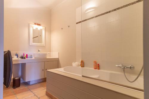 une salle de bain avec une baignoire et un lavabo dans l'établissement Le Mas de Heron, à Vidauban