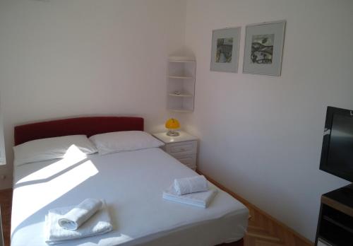 a bedroom with a white bed with towels on it at Sunny P in Primošten