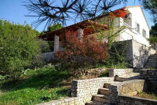 ein Haus mit einer Steinmauer davor in der Unterkunft Sunny P in Primošten