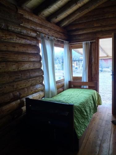a bedroom with a bed in a log cabin at ALIWWE in Uspallata