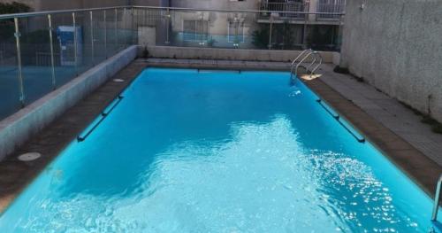 a swimming pool with blue water in a building at Depto Matucana in Santiago