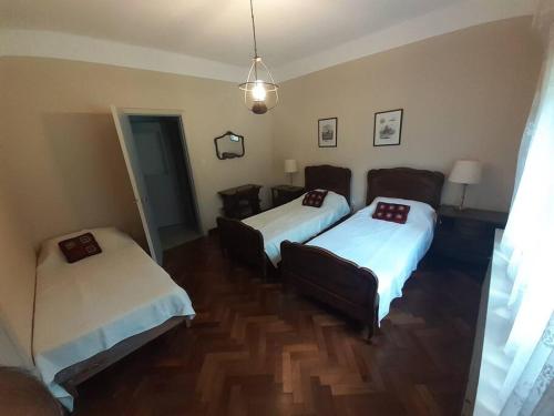 een hotelkamer met 2 bedden en een bank bij Amplia Casona de Estilo en La Falda in La Falda
