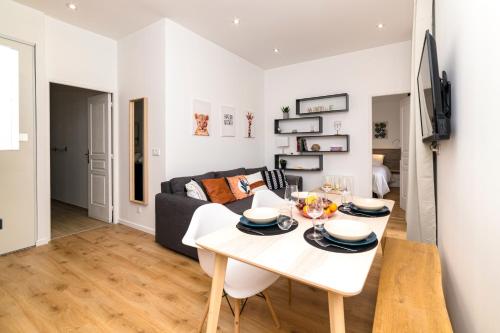 un salon avec une table blanche et un canapé dans l'établissement La Dolive - Locationtournus, à Tournus