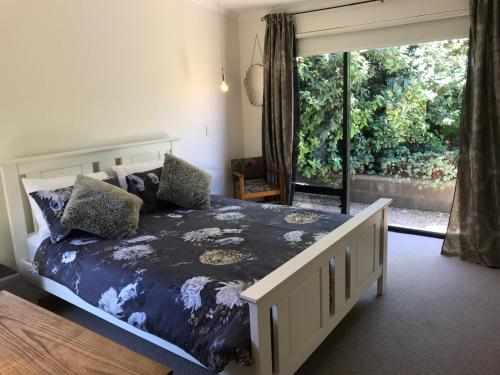 een slaapkamer met een bed en een groot raam bij Sinclair Eco House in Port Lincoln