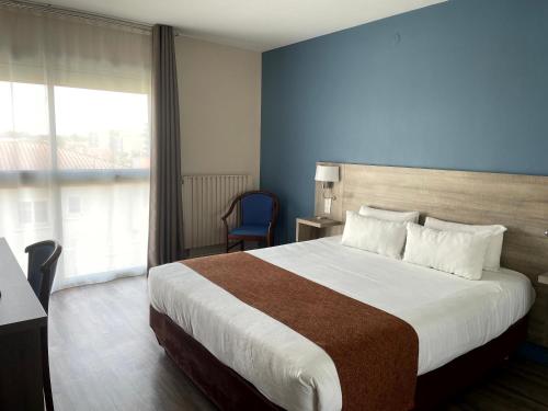um quarto de hotel com uma cama grande e uma janela em Grand Hotel em Dax