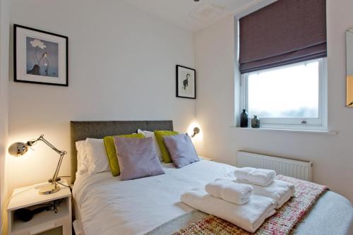 Calabria 2 - Cosy apartment في لندن: غرفة نوم عليها سرير وفوط