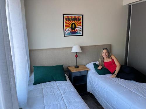 a woman sitting on a bed in a room at AIKEN 19 in San Martín de los Andes