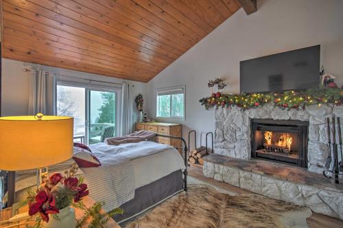 a bedroom with a fireplace with a television and a bed at Picturesque Cabin 2 Balconies, Walk to Lake! in Crestline