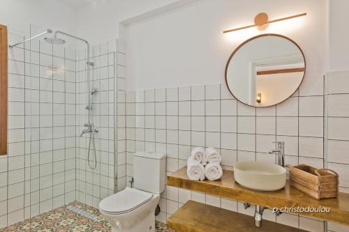 uma casa de banho com um WC, um lavatório e um espelho. em Ypsilos Beach Suites em Kyra Panagia
