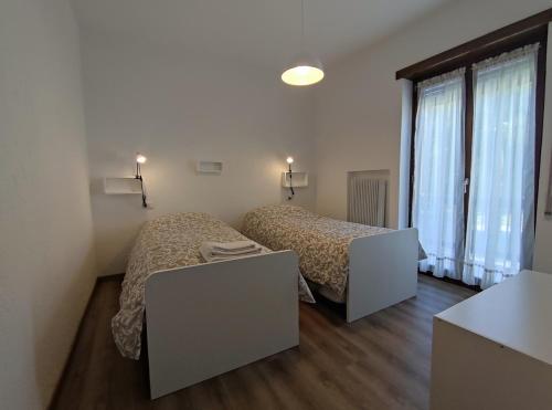 um quarto com duas camas e duas mesas em Residence Avila em Gallio
