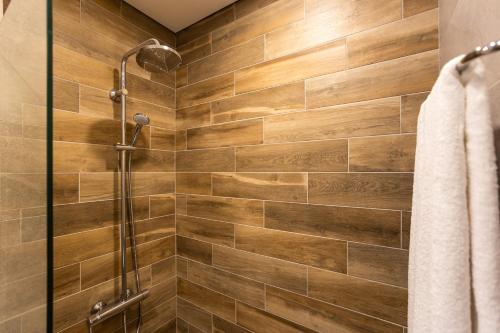 a shower in a bathroom with wooden tiles at Open Sea Residence in Byala