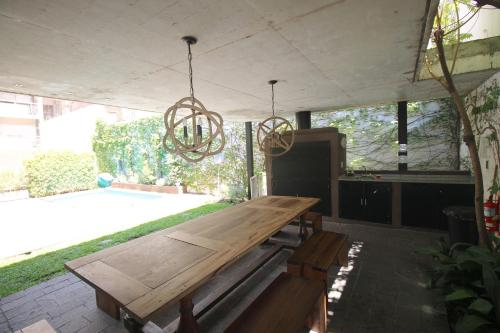 una mesa de madera en un patio con una lámpara de araña en Relax en Palermo con wifi 300MB y vista abierta en Buenos Aires