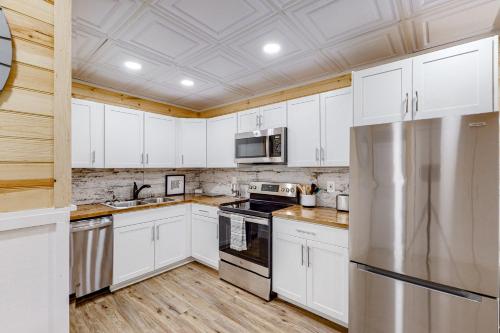 a kitchen with white cabinets and a stainless steel refrigerator at Osprey Landing in Clarkesville