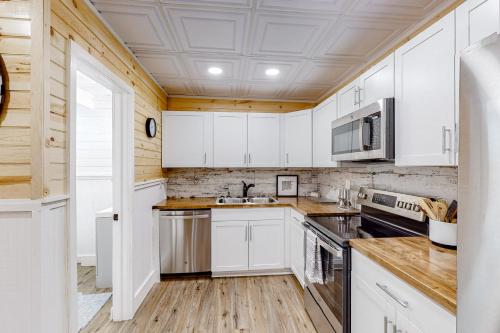 a kitchen with white cabinets and wooden floors at Osprey Landing in Clarkesville