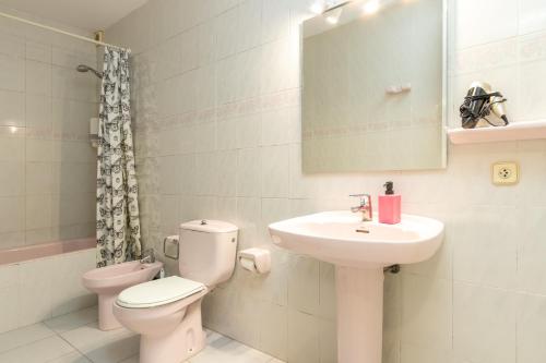 a bathroom with a sink and a toilet and a mirror at Apartaments Aiguablava in Begur