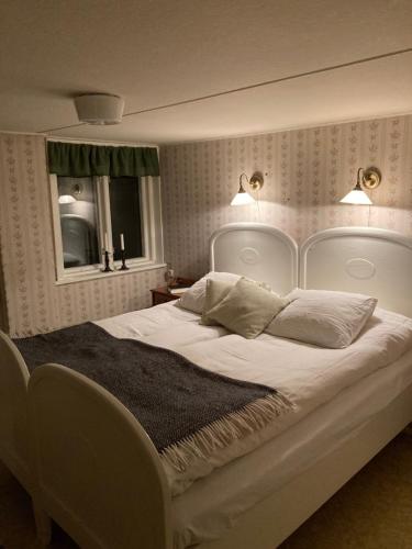 a bedroom with a large white bed with two pillows at Windalens på Österlen in Tomelilla