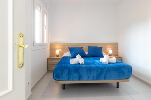 a bedroom with a blue bed with two pillows at Apartaments Aiguablava in Begur