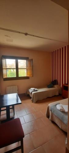 a bedroom with two beds and a table in it at El Camino de las Estrellas in Navarrete