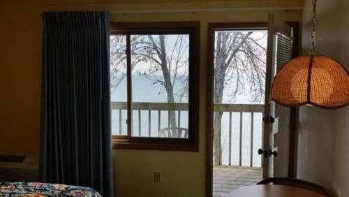 a room with a door open to a porch with a view at Algoma Beach Motel in Algoma