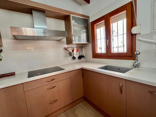 a kitchen with wooden cabinets and a sink and a window at Casa Laura by Sun & Sea Homes in Moraira